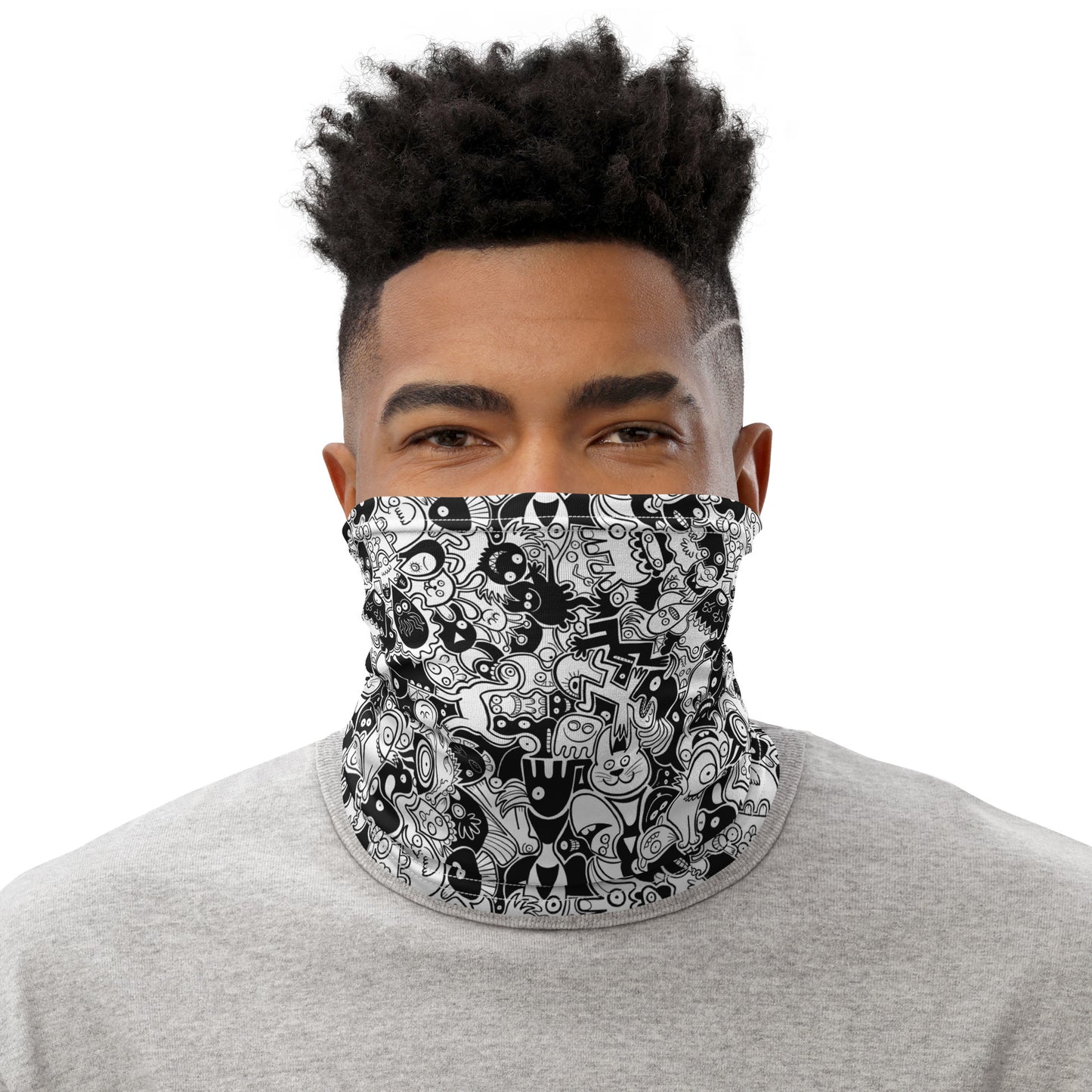 Smiling man wearing Neck Gaiter All-over printed with Joyful crowd of black and white doodle creatures. Neck warmer