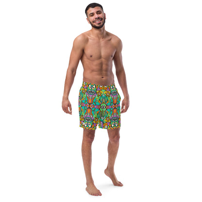 Smiling man wearing Men's swim trunks All-over printed with The vast ocean is full of doodle critters