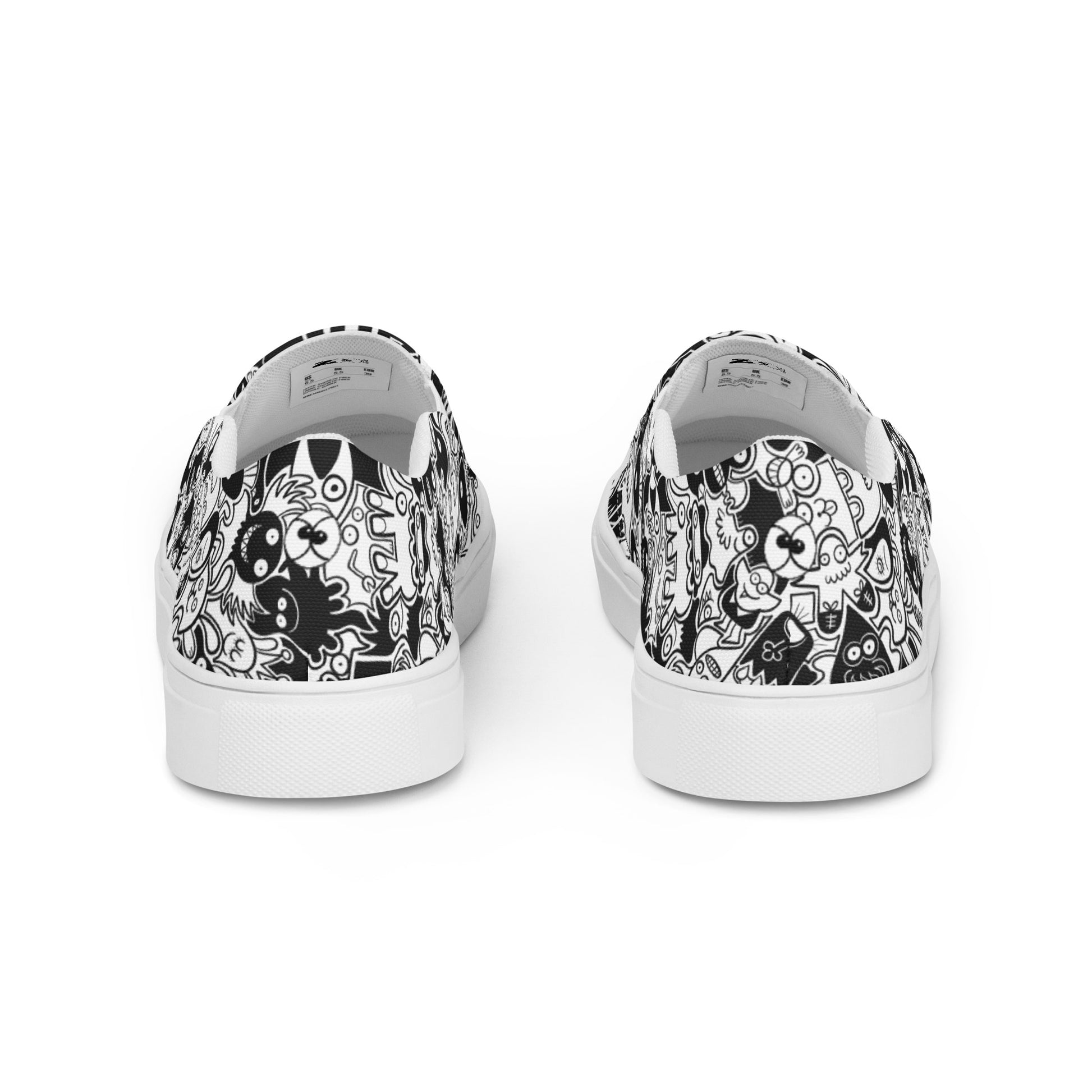 Joyful crowd of black and white doodle creatures Women’s slip-on canvas shoes. Back view